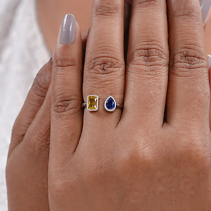 yellow emerald and blue pear cut gemstone bezel set open cuff ring on model's finger
