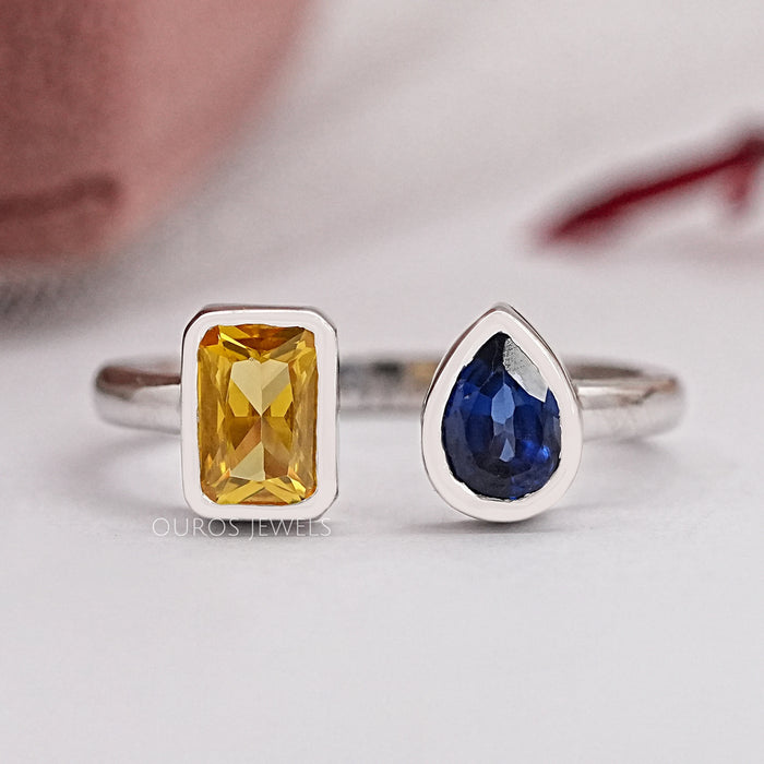 top view of yellow emerald and blue pear cut gemstone bezel set open cuff ring