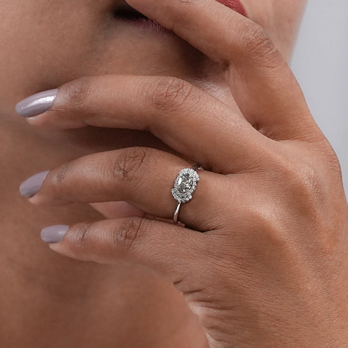 olive oval cut diamond halo engagement ring on model's hand