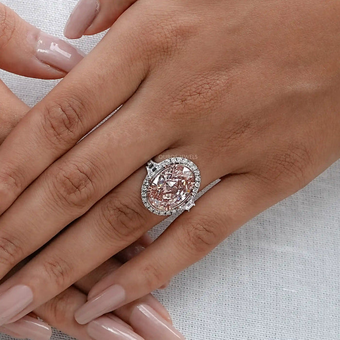 pink oval diamond with trapezoid halo wedding diamond ring on model's hand