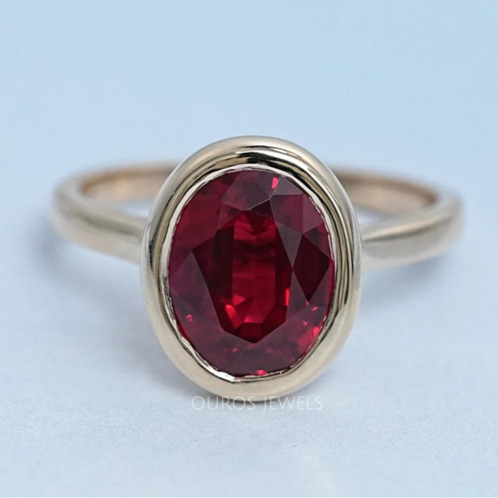 top view of oval cut ruby lab gemstone bezel set solitaire ring