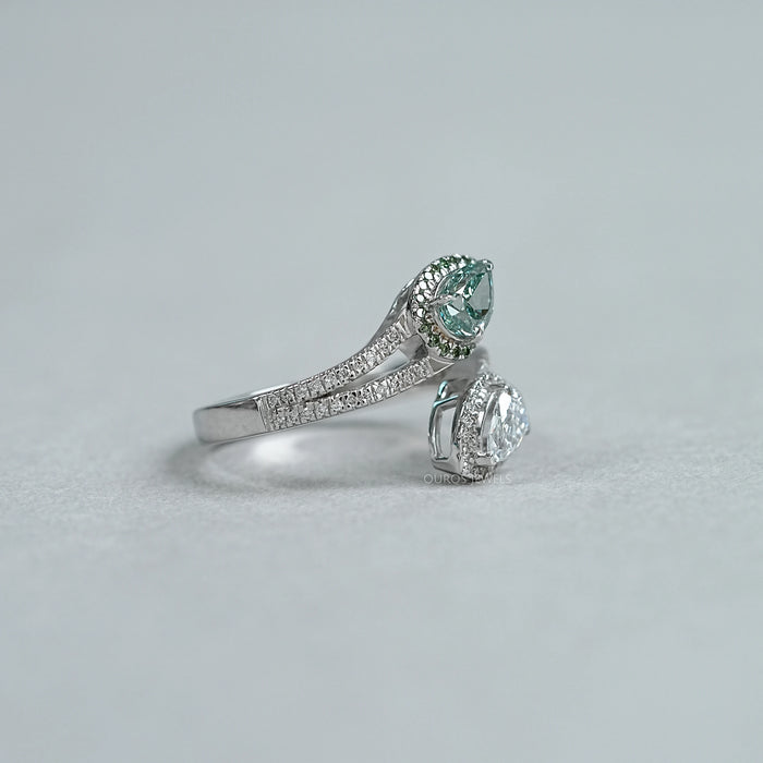 side view of fancy vivid green pear cut diamond bypass halo ring on grey fabric