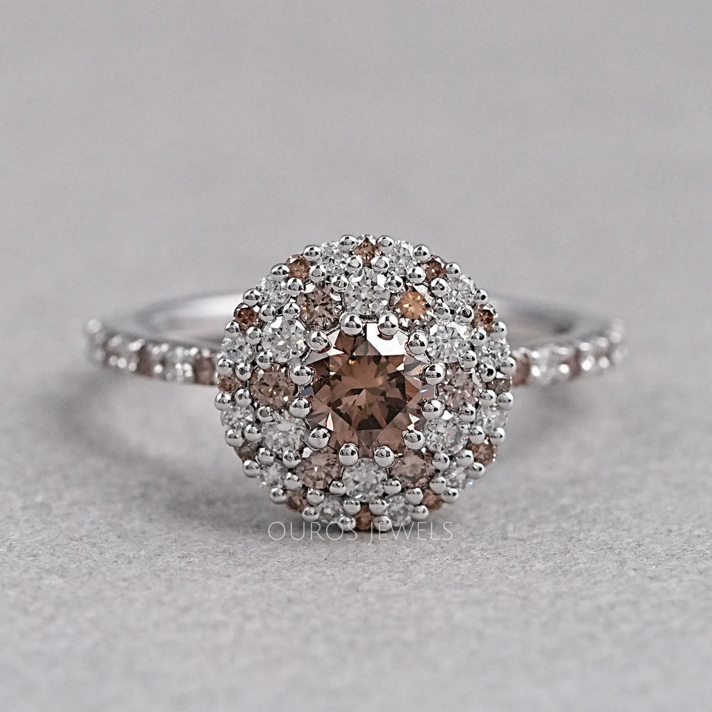 top view of brown round shape diamond cluster halo engagement ring on grey fabric