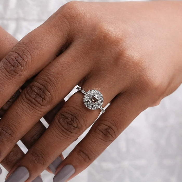 brown round shape lab diamond cluster halo engagement ring on model's finger