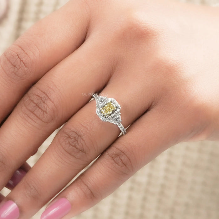 yellow radiant cut diamond three stone halo engagement ring in finger