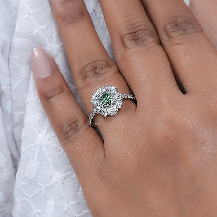 green oval cut diamond half moon halo engagement ring in finger
