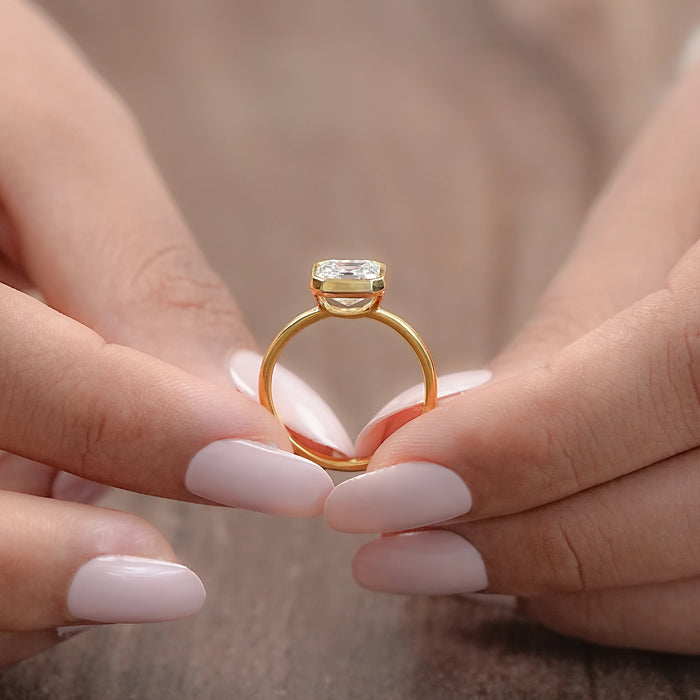 close-up view of asscher cut diamond bezel set solitaire engagement ring