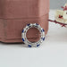 side close view of blue cushion cut and round diamond eternity wedding band 