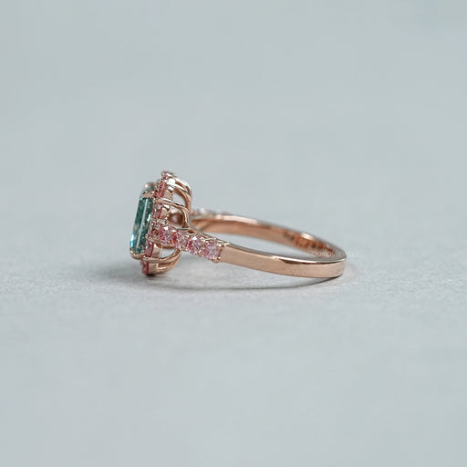 side view of green radiant cut diamond with pink diamond halo engagement ring