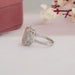 side view of pink emerald cut diamond three stone halo engagement ring