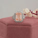 pink emerald cut diamond three stone halo engagement ring on jewelry box