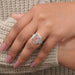 pink emerald cut diamond three stone halo engagement ring on model's finger