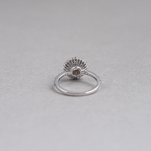 back view of brown round shape diamond cluster halo engagement ring on grey fabric