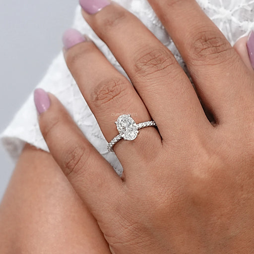front view of oval-shaped diamond solitaire accent engagement ring on model's finger