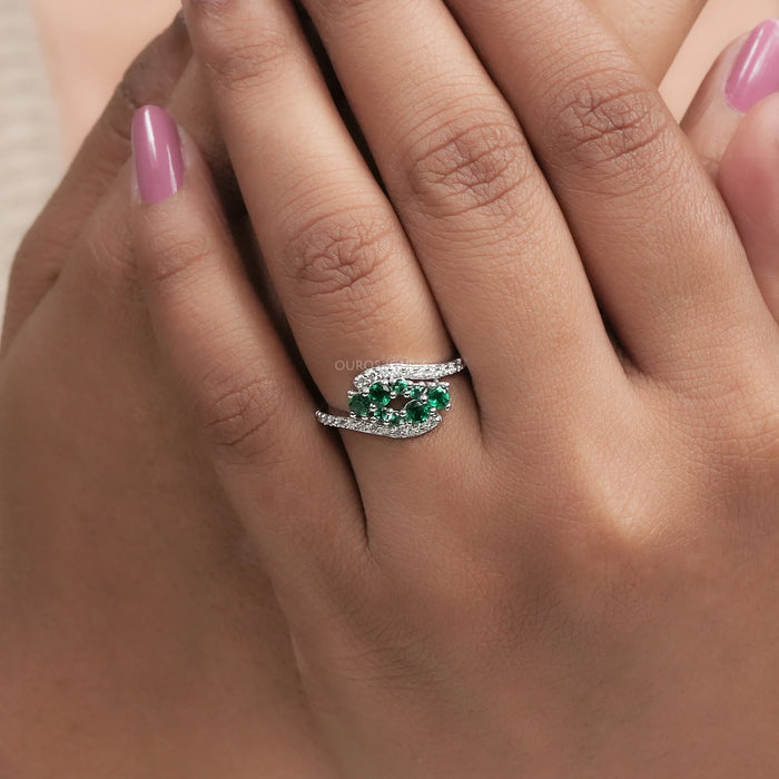 green round gemstone cluster bypass engagement ring on model's finger