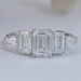 front view of emerald cut lab diamond five stone engagement ring on grey fabric