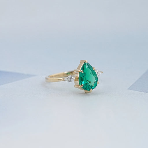 side view of green pear gemstone and kite cut diamond three stone engagement ring
