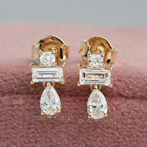 front view of pear and baguette cut diamond prong setting drop earrings gold