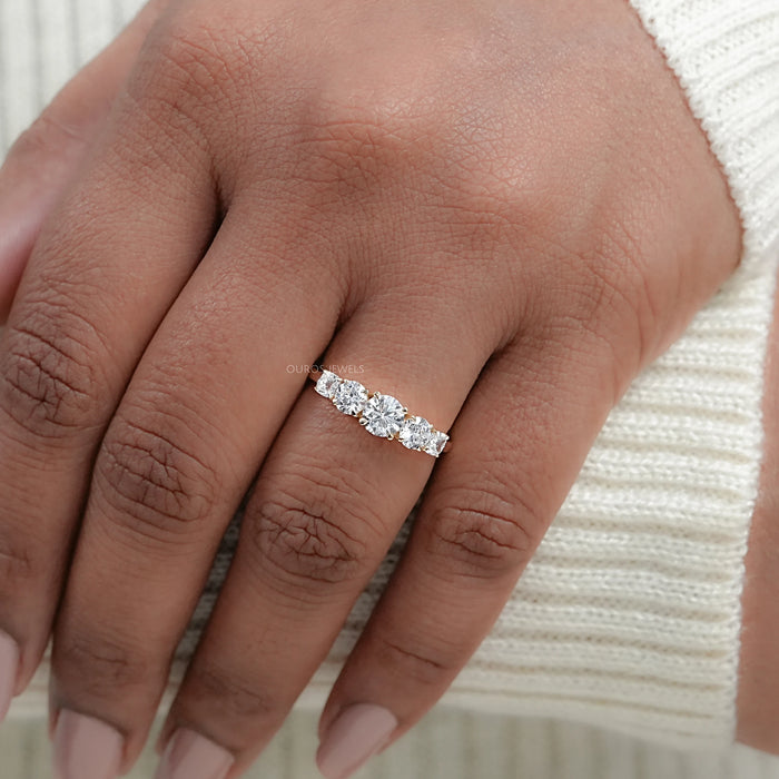 cushion and round cut lab diamond five stone engagement ring in finger