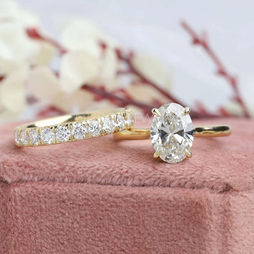 front view of oval cut diamond bridal ring set with yellow gold band on jewelry box