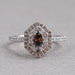 top view of oval cut brown diamond double halo engagement ring on grey fabric
