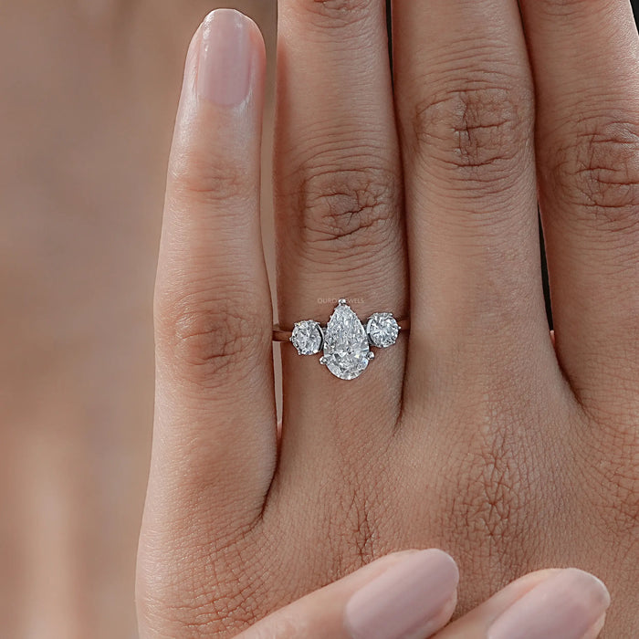 three stone pear cut lab diamond hidden halo engagement ring in finger