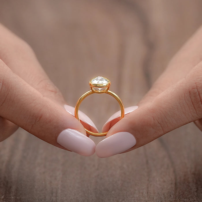 close-up view of a pear-shaped diamond bezel set engagement ring