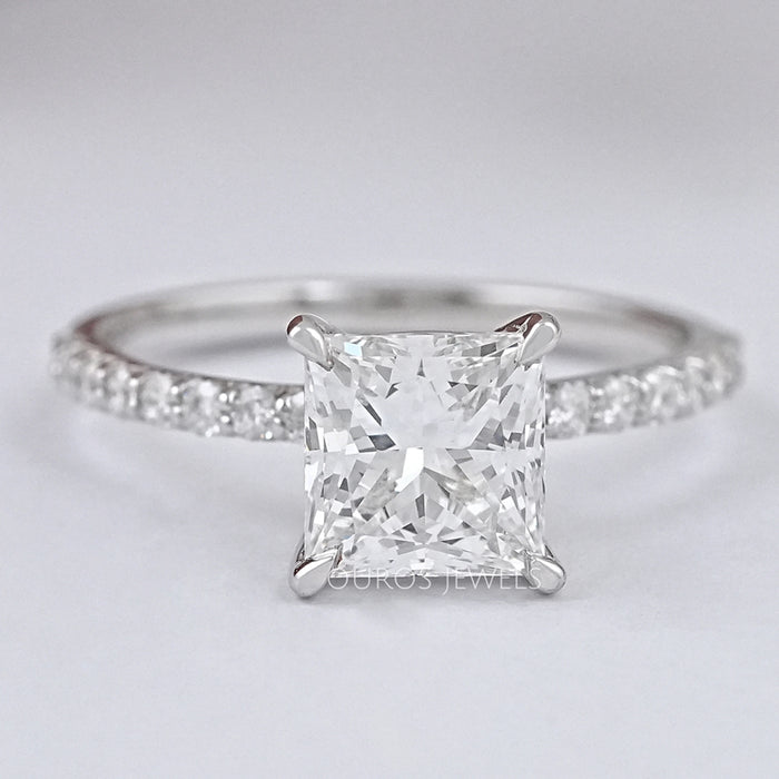 front view of princess cut diamond solitaire accent engagement ring on grey fabric