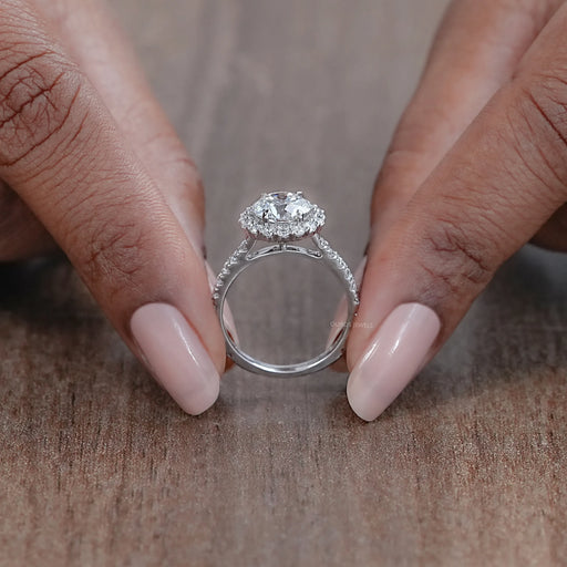 close view of round cut lab diamond halo engagement ring on brown background
