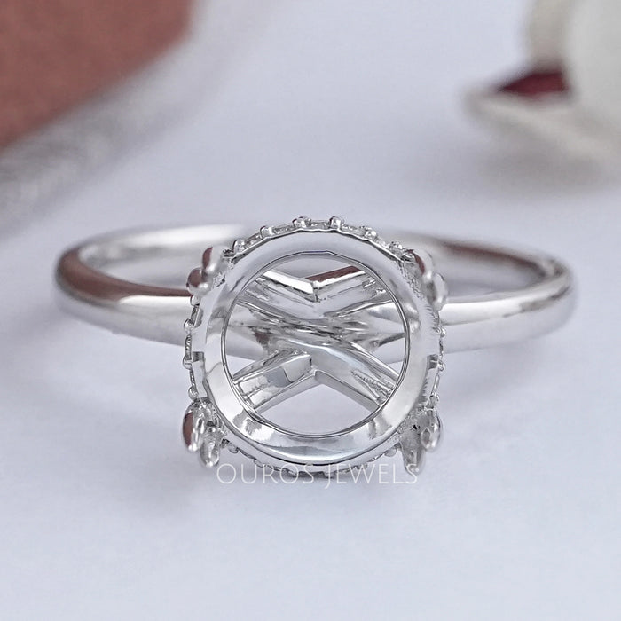 front view of round shape hidden halo semi mount engagement ring on grey fabric