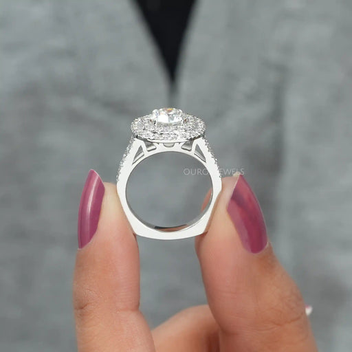 close view of round cut lab diamond double halo engagement ring on grey fabric