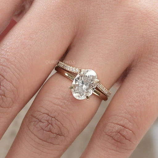 front view of oval-cut lab diamond curved bridal ring set with yellow gold band
