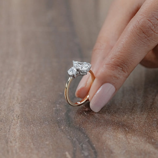side view of three stone pear cut diamond hidden halo engagement ring