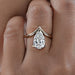 front angle of v shape pear cut diamond solitaire engagement ring in finger