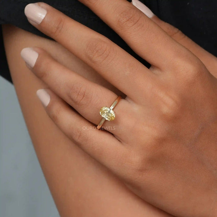 yellow oval cut lab diamond solitaire engagement ring in model's finger