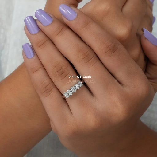 oval cut lab grown diamond five stone wedding ring on model's finger