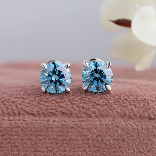 front view of blue round cut diamond solitaire stud earrings white gold