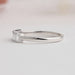 side view of emerald cut lab diamond five stone wedding band on grey fabric