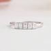 front view of emerald cut lab diamond five stone wedding band on grey fabric