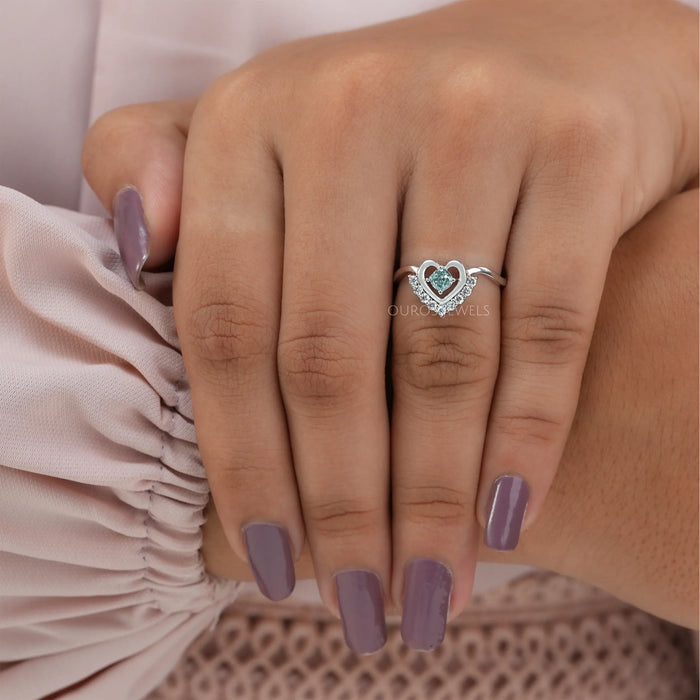 In finger front view of cushion cut diamond engagement ring with curved band set in 14k white gold.