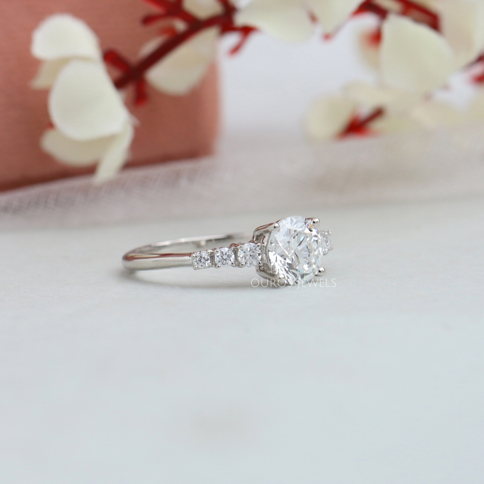 side view of 7 stone round-cut diamond solitaire accent engagement ring on fabric