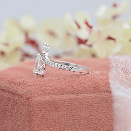 left view of chevron-shaped pear-cut diamond solitaire engagement ring on jewelry box