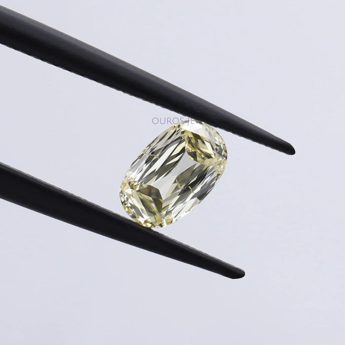 vivid yellow antique elongated cushion cut diamond loose held with tweezer