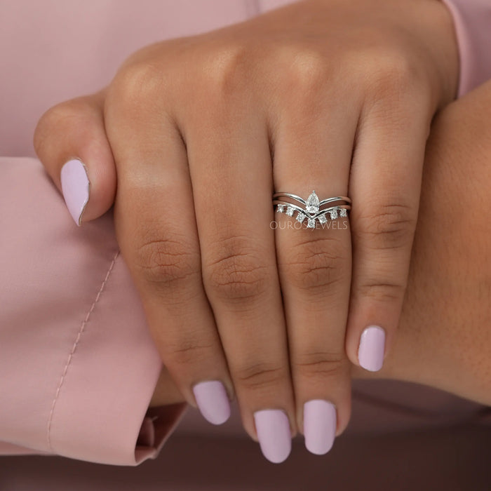 Finger view of pear shaped with round side diamonds ring crafted with curved band & white gold.