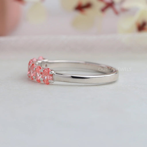 side view of pink oval-cut seven stone lab diamond wedding bands