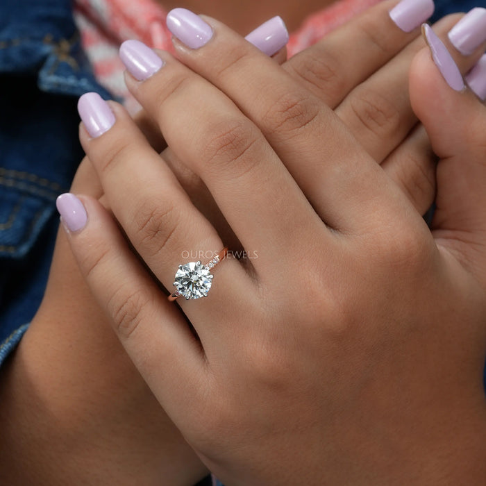 rose-cut round diamond solitaire accent ring with rose gold band on model's finger